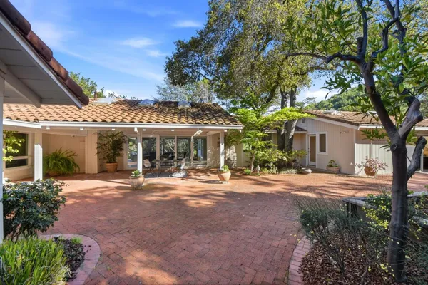 a front view of a house with a garden and trees