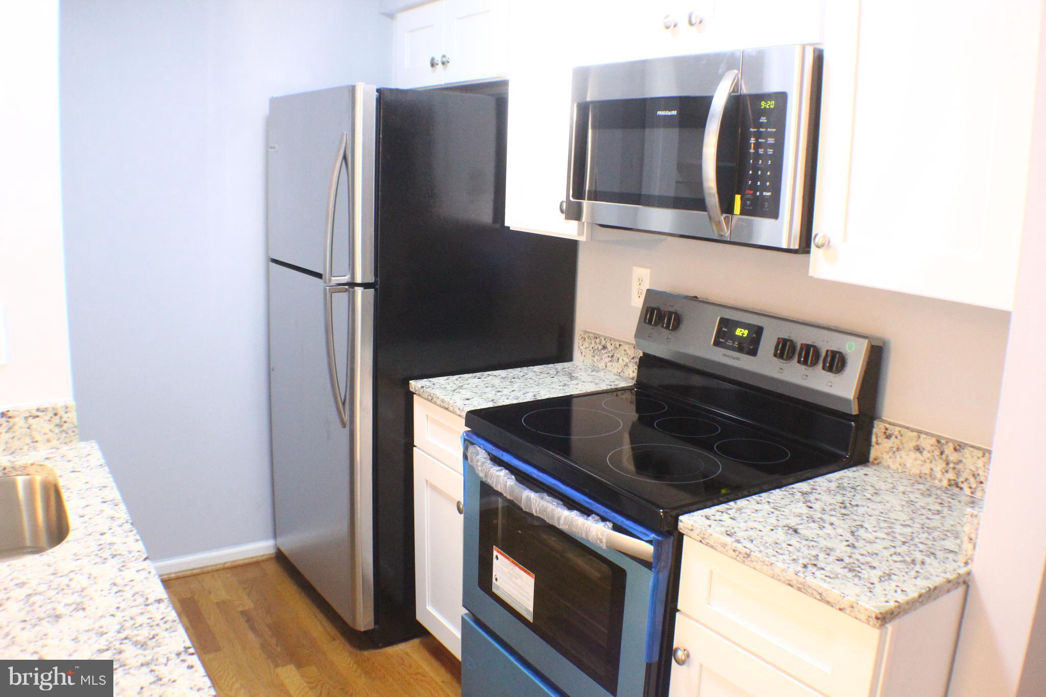 5816 Royal Ridge Drive, Unit D Springfield, VA 22152 - Photo 2 of 15 a kitchen with stainless steel appliances granite countertop a refrigerator and a stove