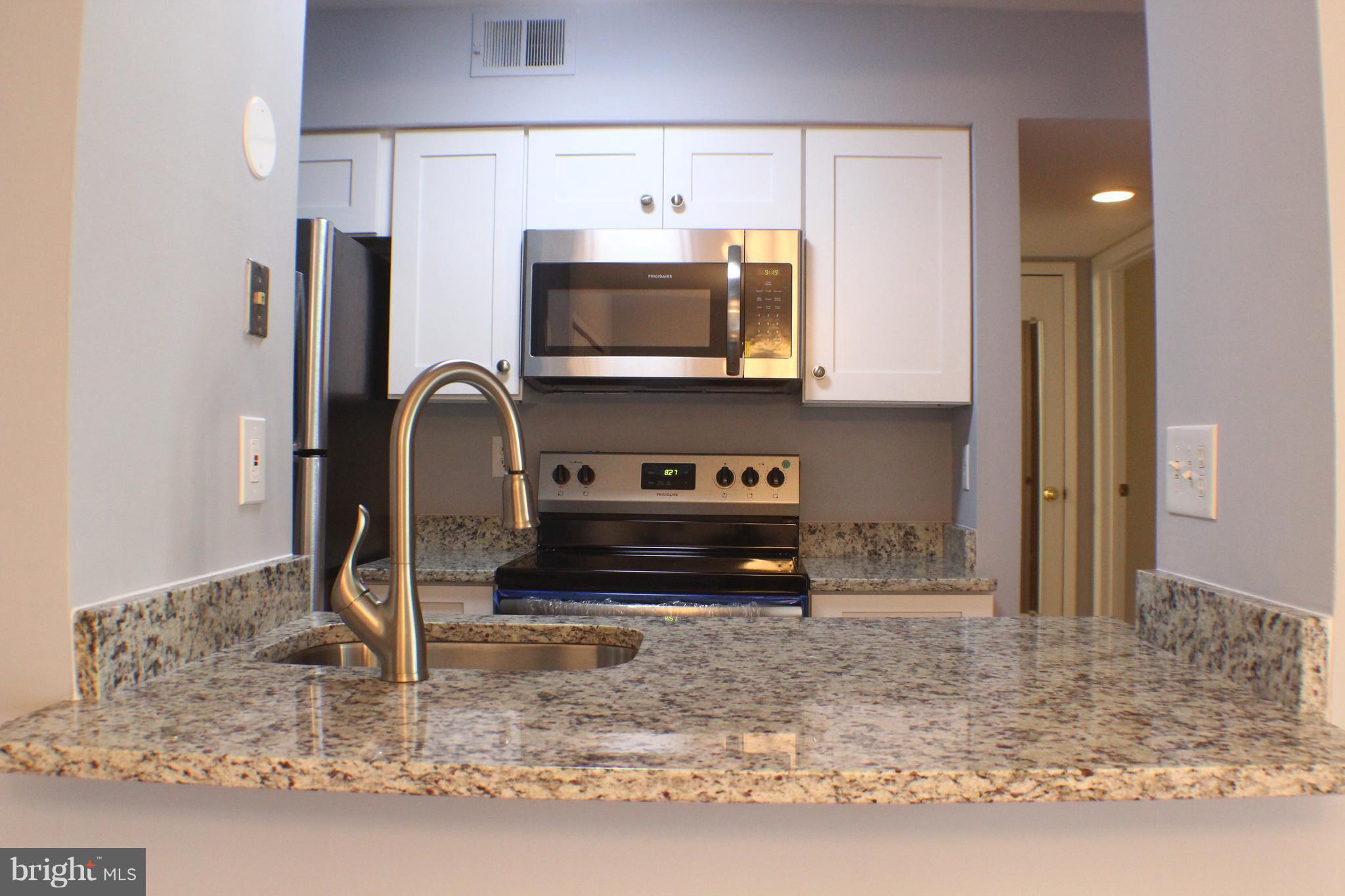 5816 Royal Ridge Drive, Unit D Springfield, VA 22152 - Photo 3 of 15 a kitchen with a sink a microwave and cabinets