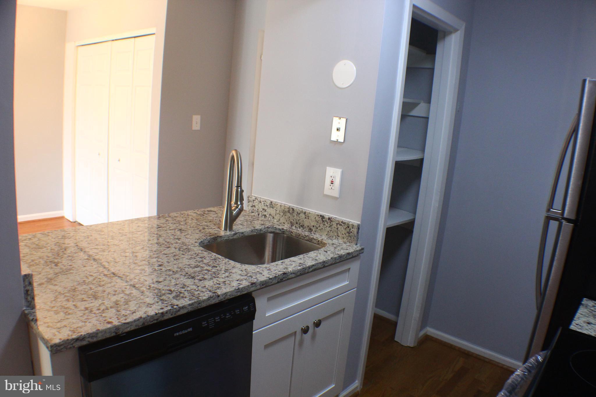 5816 Royal Ridge Drive, Unit D Springfield, VA 22152 - Photo 5 of 15 a kitchen with granite countertop a sink and a mirror