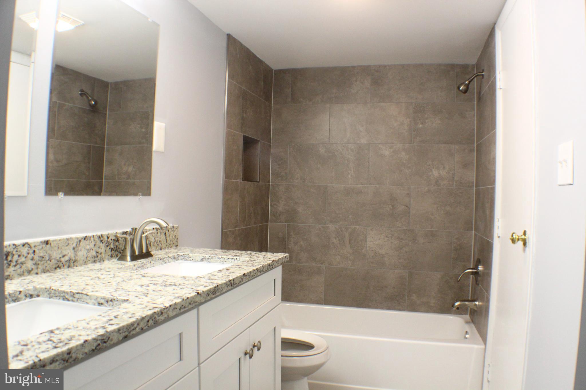 5816 Royal Ridge Drive, Unit D Springfield, VA 22152 - Photo 7 of 15 a bathroom with a granite countertop sink a toilet and bathtub