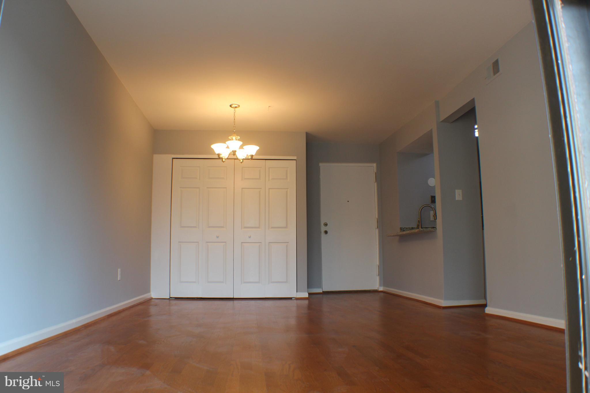 5816 Royal Ridge Drive, Unit D Springfield, VA 22152 - Photo 9 of 15 an empty room with wooden floor and chandelier