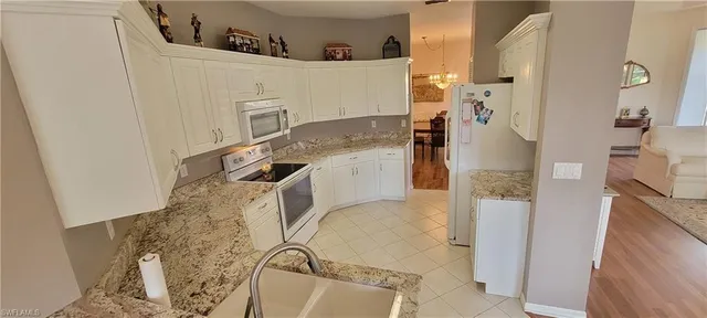 a kitchen with stainless steel appliances granite countertop a refrigerator sink and cabinets