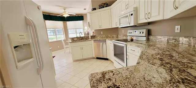 a kitchen with stainless steel appliances granite countertop a refrigerator a stove and a wooden floors