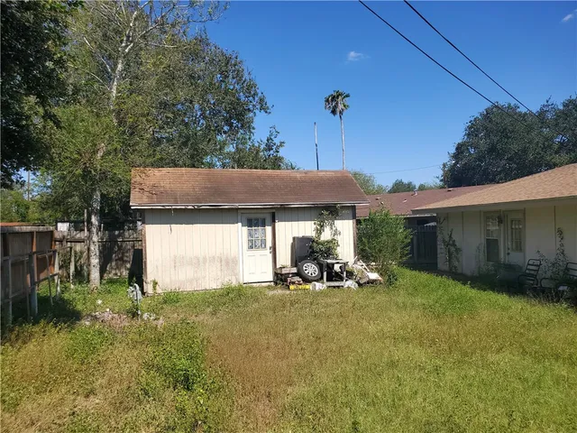 a view of a house with backyard and sitting area