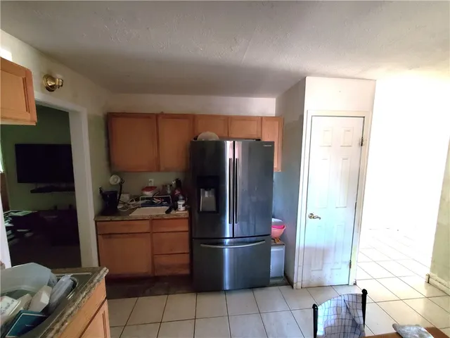 a kitchen with a refrigerator sink and cabinets