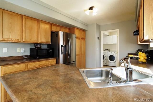 20000 Mitchell Place, Unit 53 Denver, CO 80249 - Photo 11 of 40 a kitchen with a refrigerator and a sink