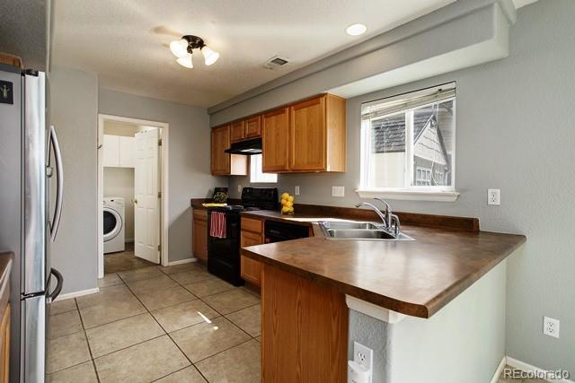 20000 Mitchell Place, Unit 53 Denver, CO 80249 - Photo 13 of 40 a kitchen with a refrigerator a sink and a stove