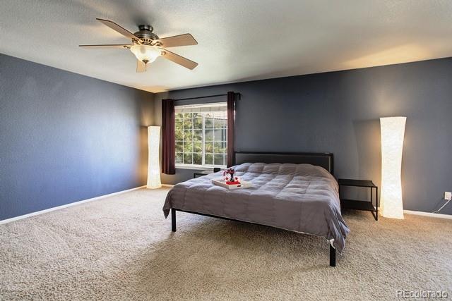 20000 Mitchell Place, Unit 53 Denver, CO 80249 - Photo 15 of 40 a bedroom with a bed window and a ceiling fan