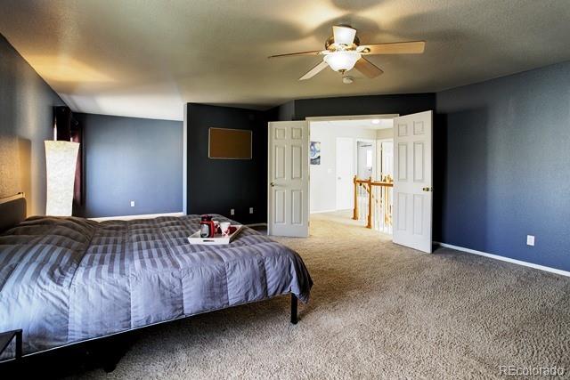 20000 Mitchell Place, Unit 53 Denver, CO 80249 - Photo 17 of 40 a bedroom with a bed and a chandelier