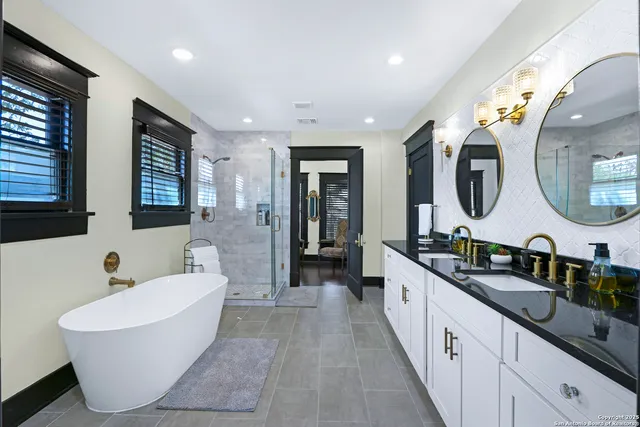 a spacious bathroom with a double vanity sink double mirror and bathtub