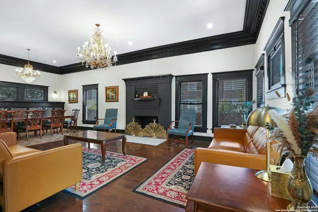 a living room with furniture chandelier and a rug