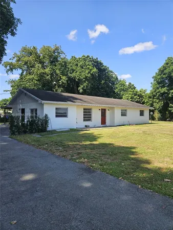 a front view of house with yard and trees in the background