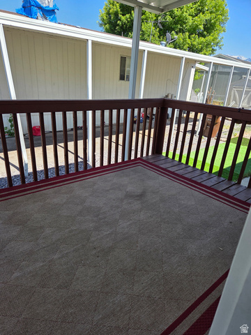 1275 Thrush Road Salt Lake City, UT 84123 - Photo 3 of 20 Outdoor deck with wood railings and a patterned floor covering
