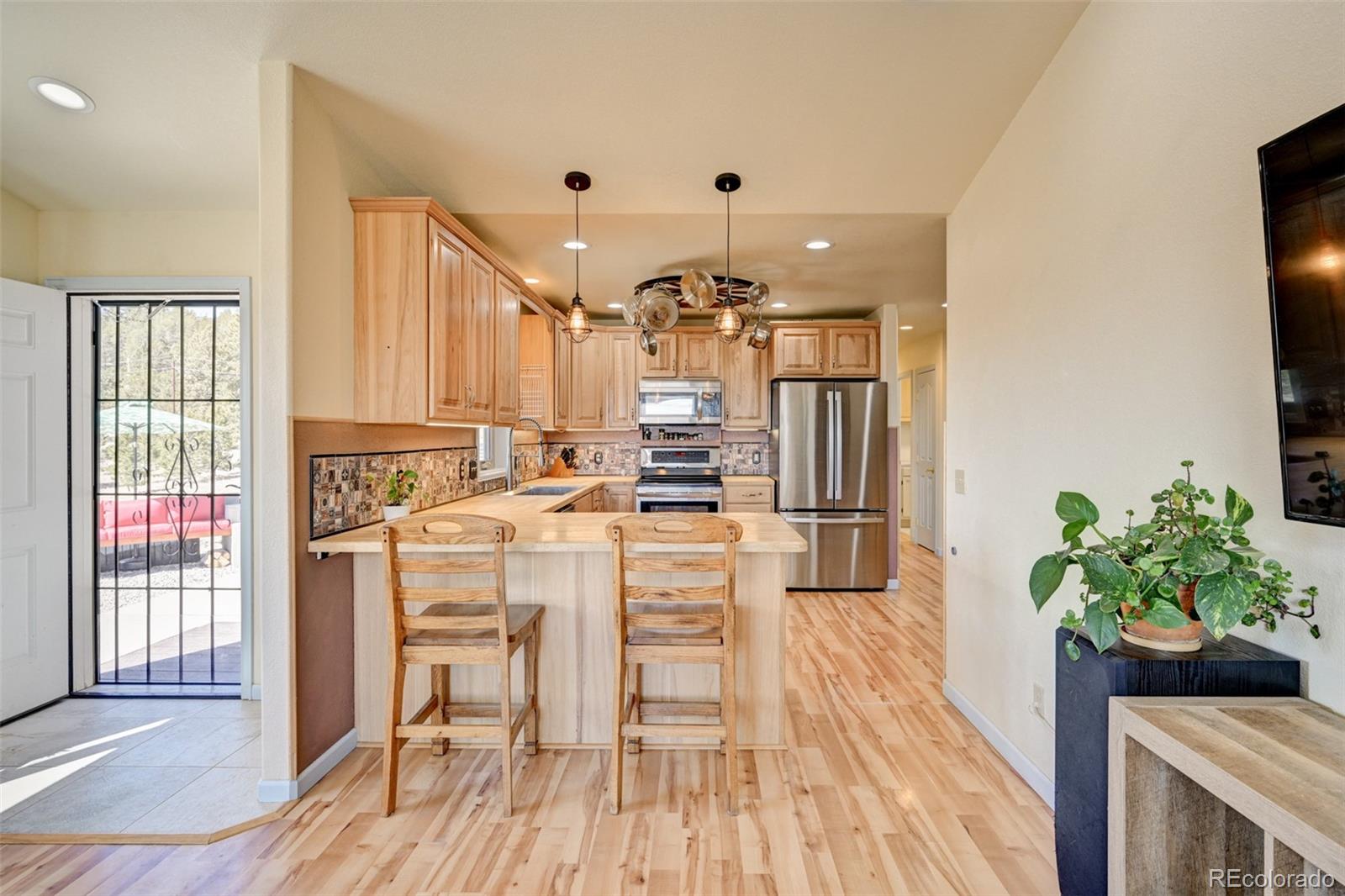 9473 Ranch Road Hartsel, CO 80449 - Photo 7 of 50 a kitchen with kitchen island a large counter top space a sink stainless steel appliances and cabinets
