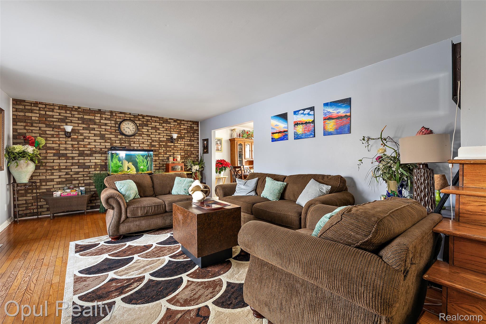 8855 Gross Road Dexter, MI 48130 - Photo 18 of 45 Living area featuring wood-finish flooring and a partial brick-look accent wall