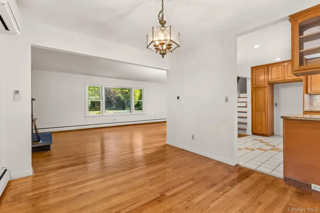 a view of a room with wooden floor a ceiling fan and windows
