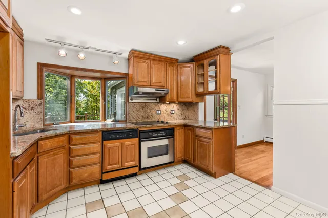 a kitchen with stainless steel appliances granite countertop a stove sink and cabinets