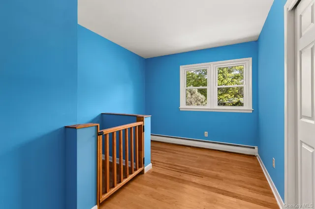 a view of an empty room with window and stairs