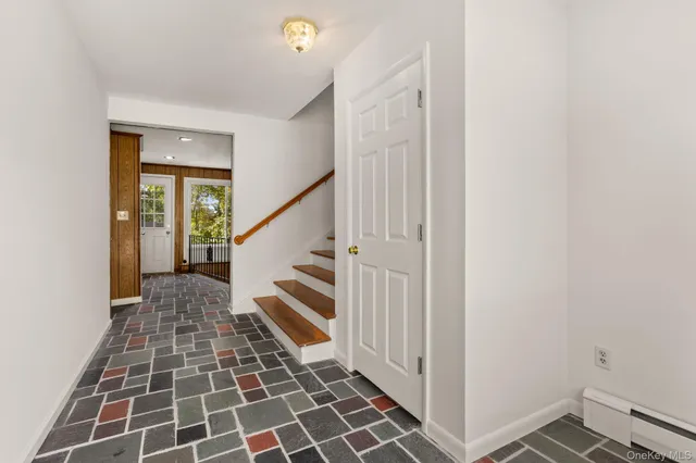 a view of a hallway with wooden floor and a bathroom