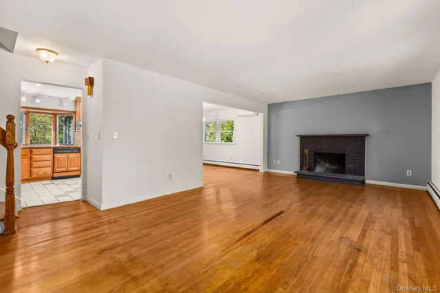 a view of empty room with wooden floor and fireplace