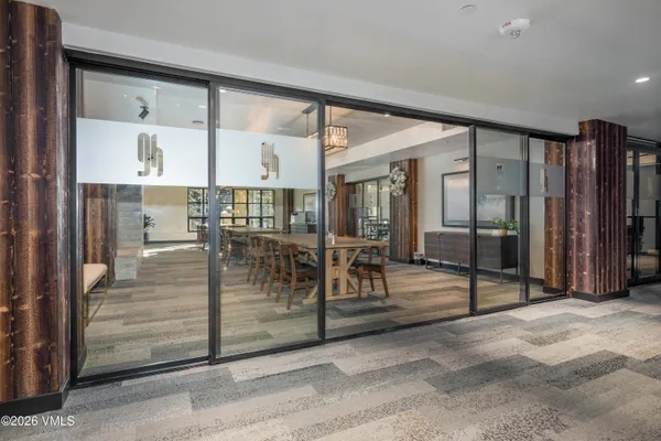 a dining hall with stainless steel appliances a dining table and chairs with wooden floor