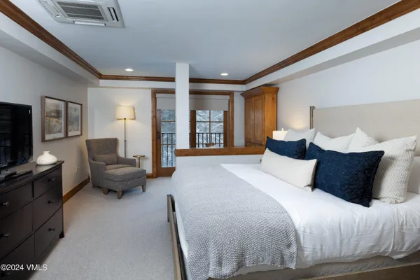 a bedroom with a bed couch and a flat tv screen