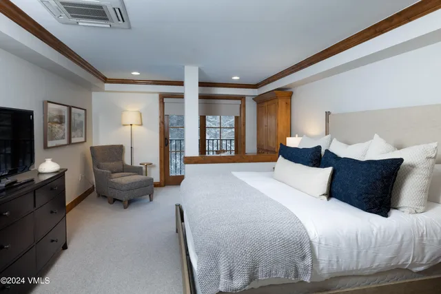 a bedroom with a bed couch and a flat tv screen