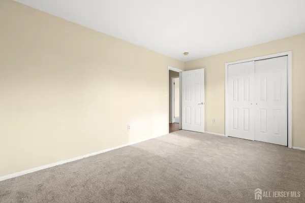 a view of a hallway with wooden floor and closet