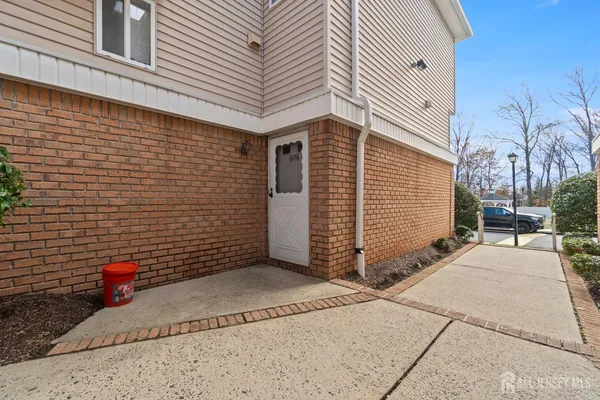 front view of house with a yard and potted plants