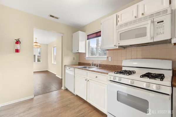 a kitchen with granite countertop cabinets stainless steel appliances and wooden floor
