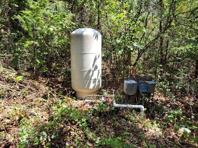 a view of a house with large trees and playing area