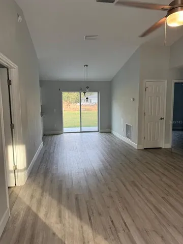 an empty room with wooden floor and window