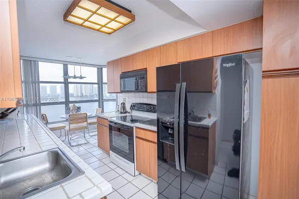 a kitchen with stainless steel appliances a sink a stove cabinets and a window