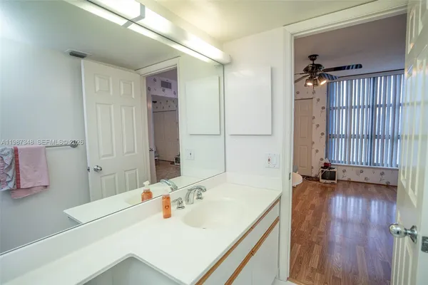 a view of a hallway with a refrigerator and cabinet