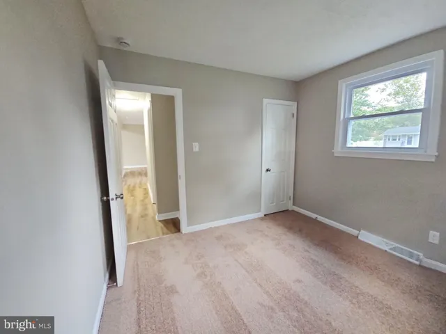 an empty room with windows and closet