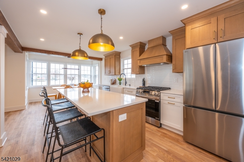 43 East Shore Road Denville, NJ 07834 - Photo 9 of 45 a open kitchen with stainless steel appliances granite countertop a stove refrigerator a dining table and chairs with wooden floor