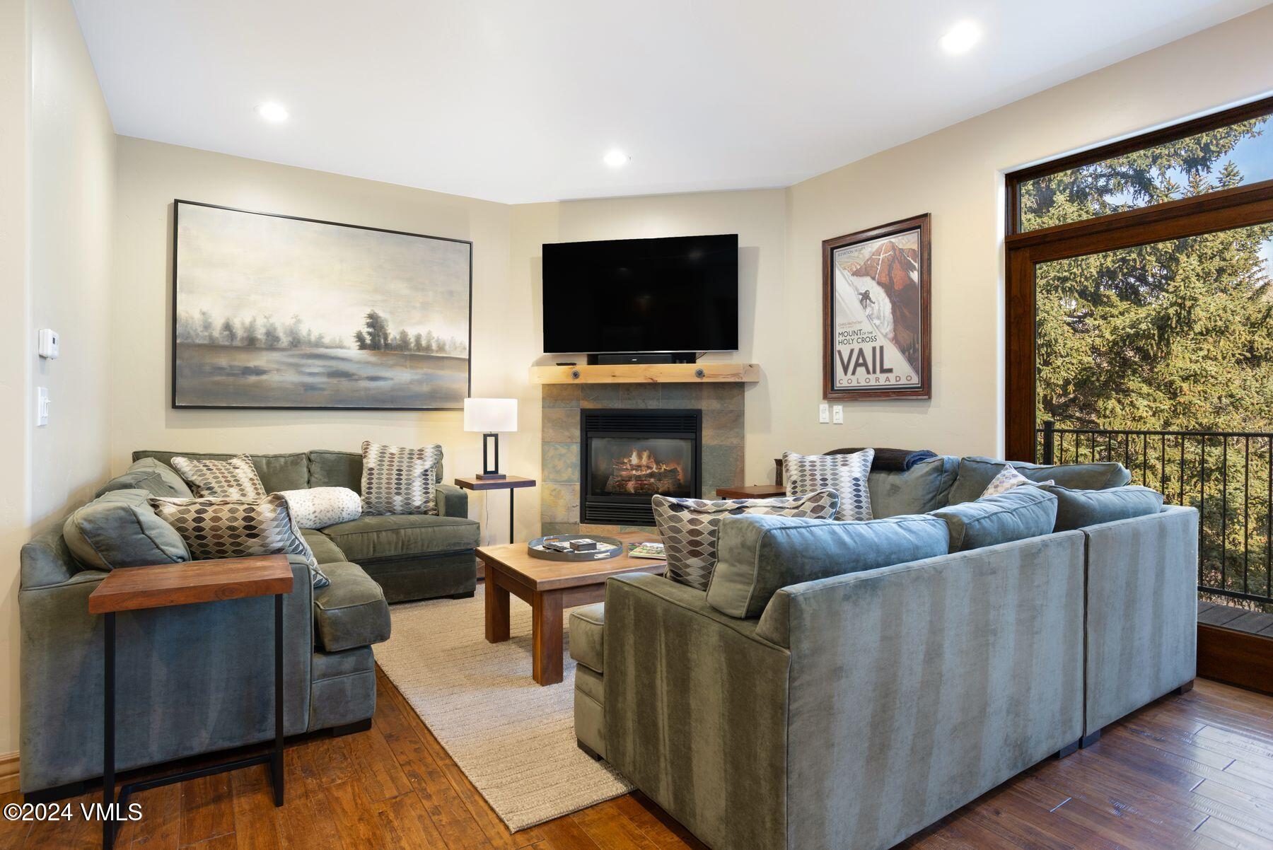 39555 Highway 6, Unit E Avon, CO 81620 - Photo 3 of 42 a living room with furniture a flat screen tv and a fireplace