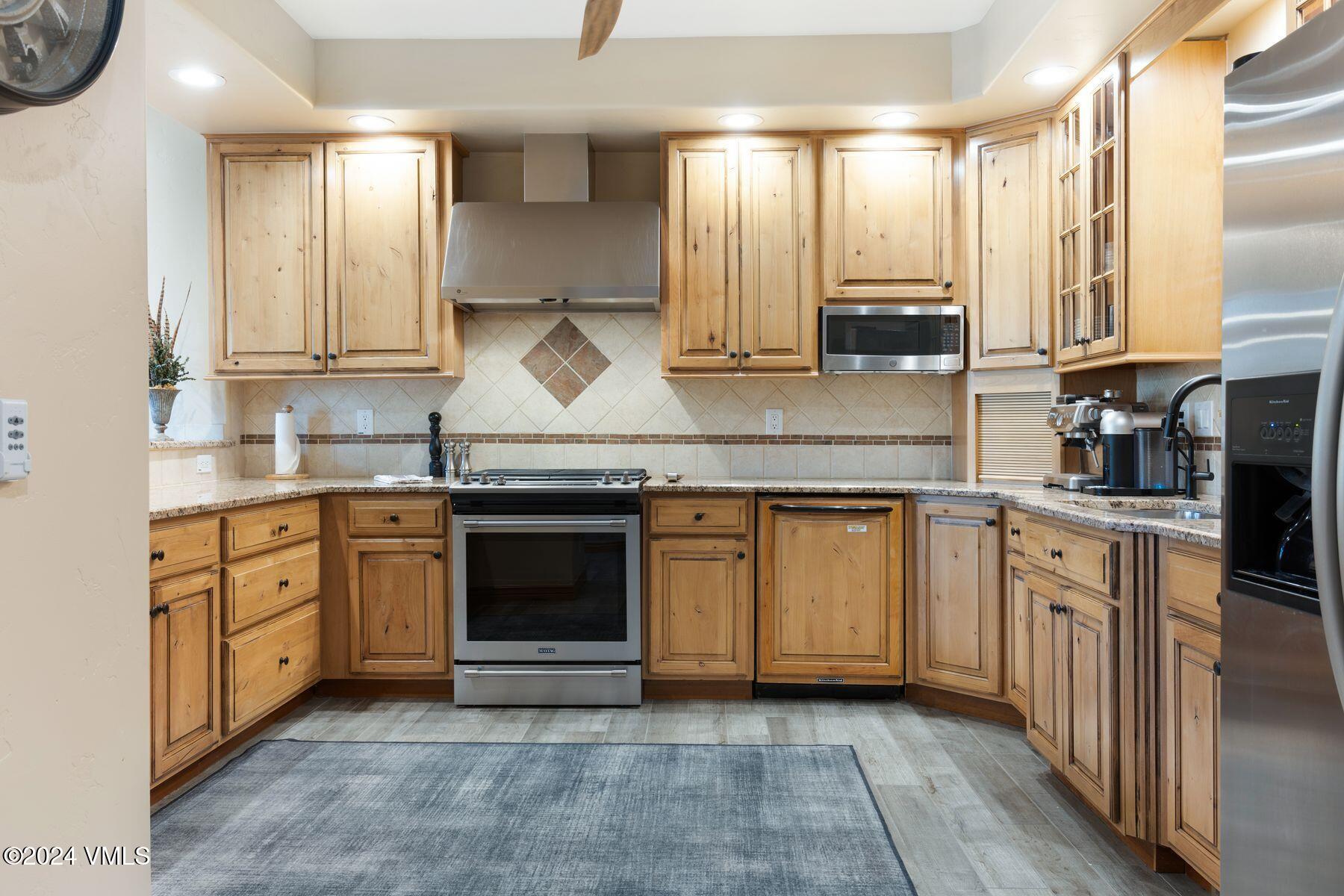 39555 Highway 6, Unit E Avon, CO 81620 - Photo 4 of 42 a kitchen with stainless steel appliances granite countertop a stove a sink and white cabinets