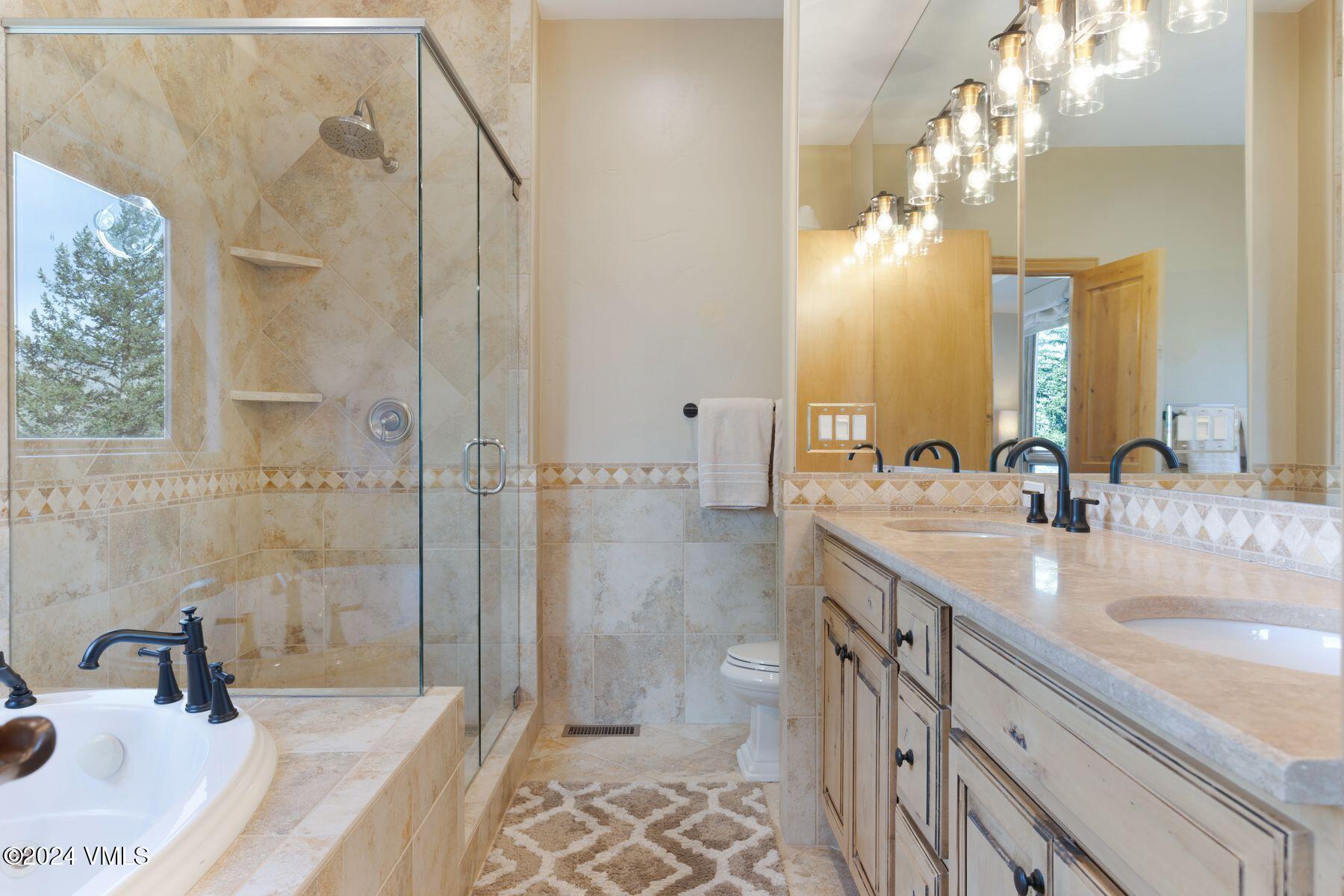 39555 Highway 6, Unit E Avon, CO 81620 - Photo 6 of 42 a bathroom with a granite countertop sink a mirror and a shower