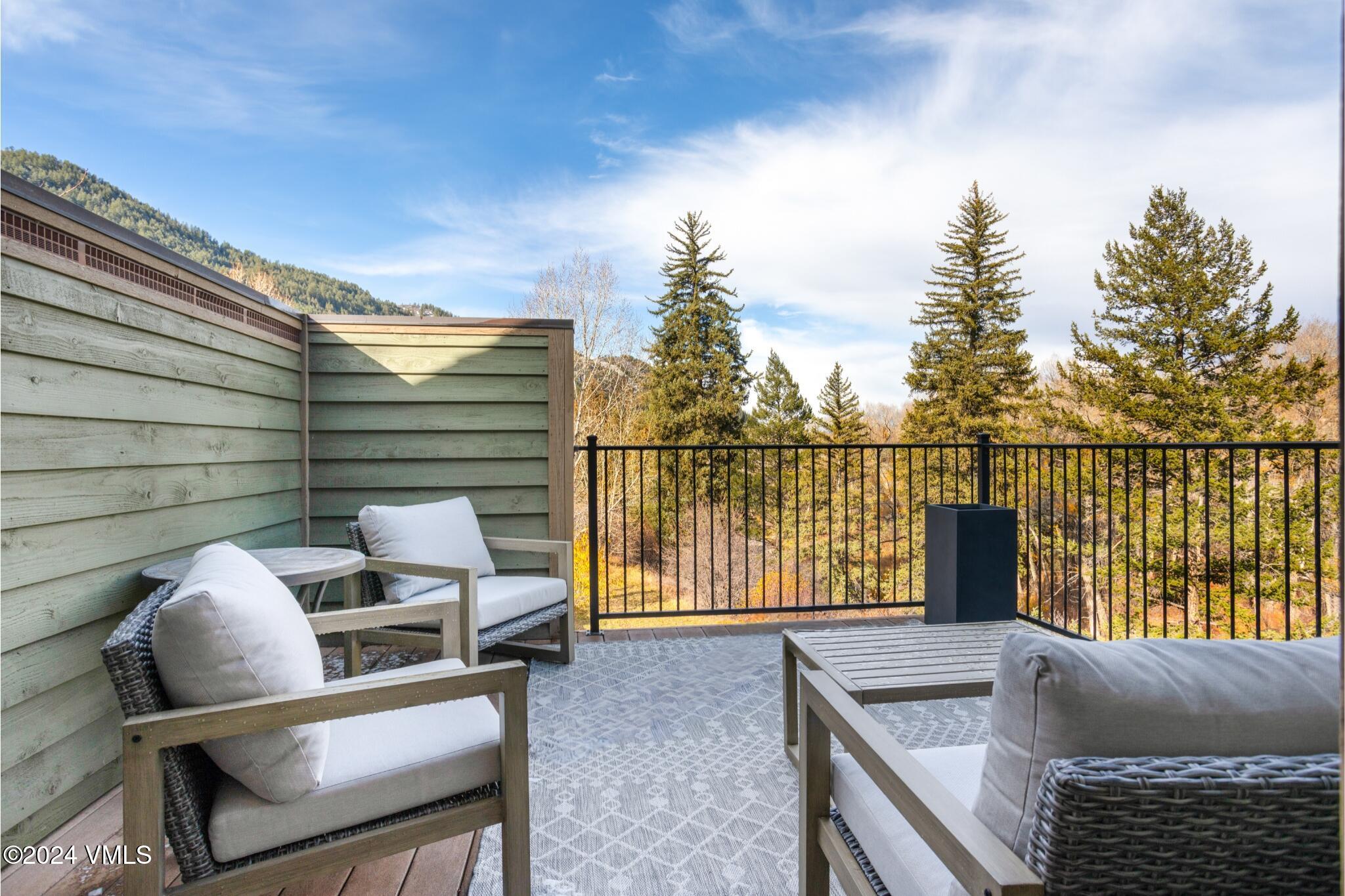 39555 Highway 6, Unit E Avon, CO 81620 - Photo 8 of 42 a balcony with a couch and wooden fence