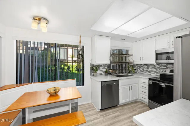 a kitchen with stainless steel appliances granite countertop a sink dishwasher stove and oven