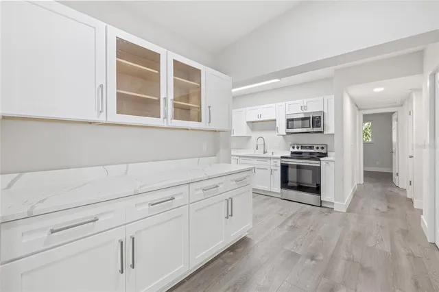 a kitchen with stainless steel appliances white cabinets and a window