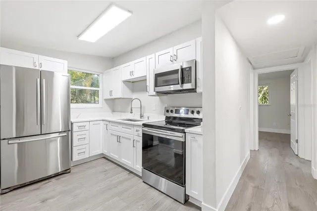 a kitchen with stainless steel appliances a stove sink and microwave