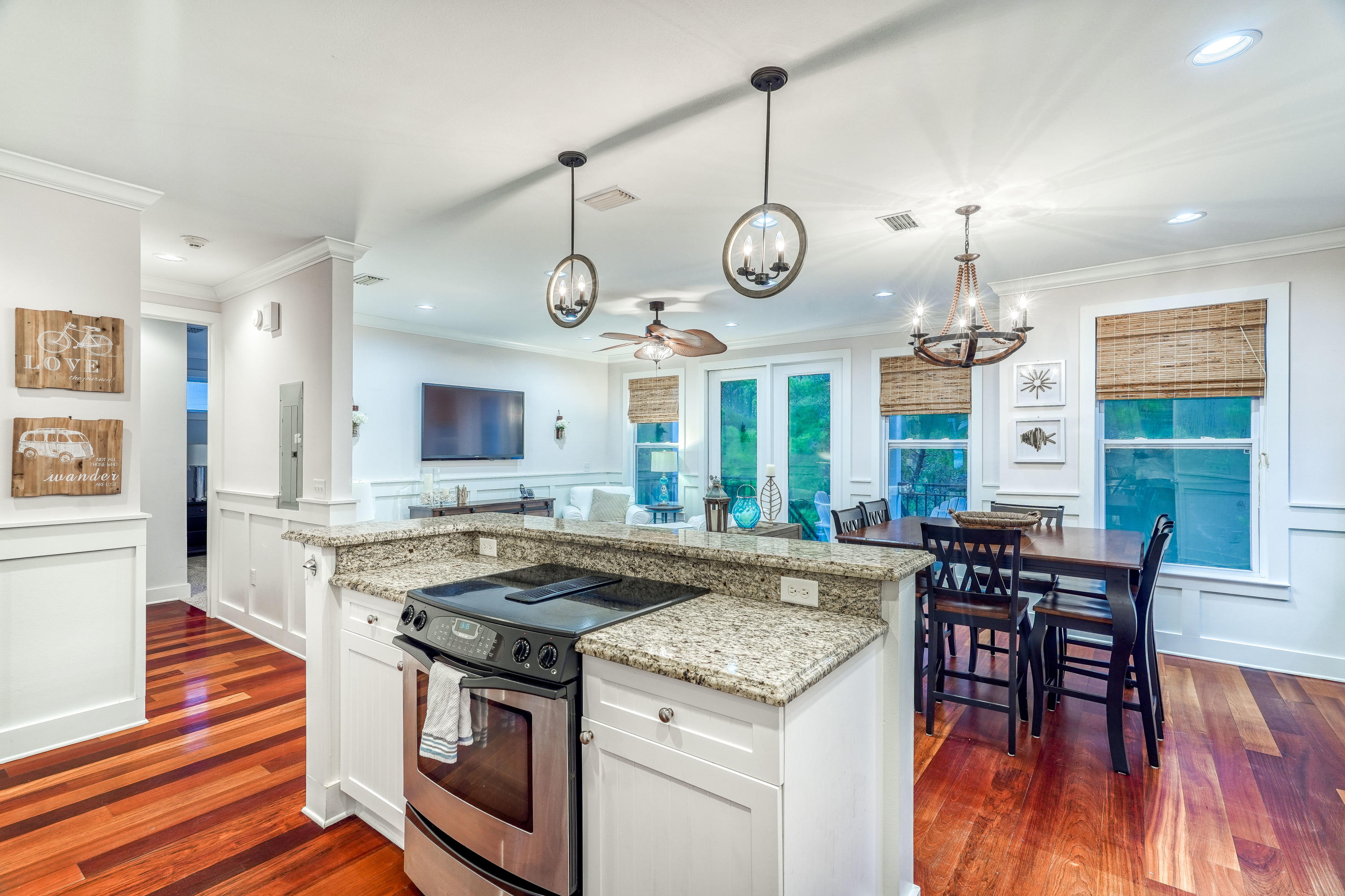 43 Lifeguard Loop East Inlet Beach, FL 32461 - Photo 11 of 44 a kitchen with stainless steel appliances granite countertop stove a microwave oven a dining table and chairs with wooden floor