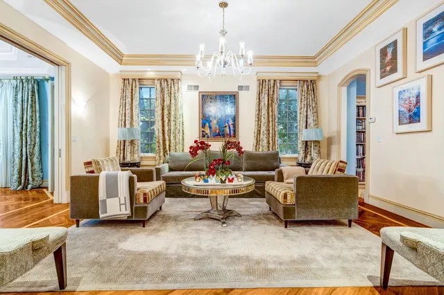 a view of a dining room with furniture a chandelier and a window