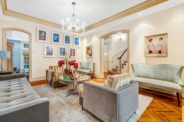 a dining room with furniture a chandelier and wooden floor