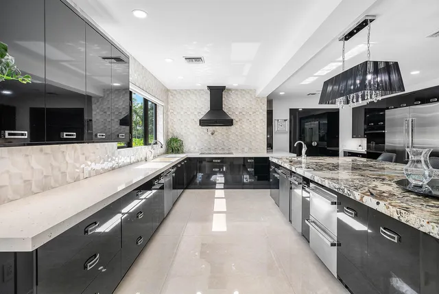 a large kitchen with stainless steel appliances double vanity and a large window