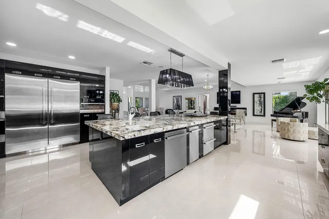 a kitchen with granite countertop a refrigerator and a sink