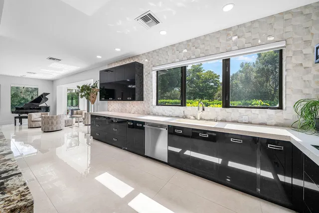 a kitchen with granite countertop a table chairs and wooden cabinets